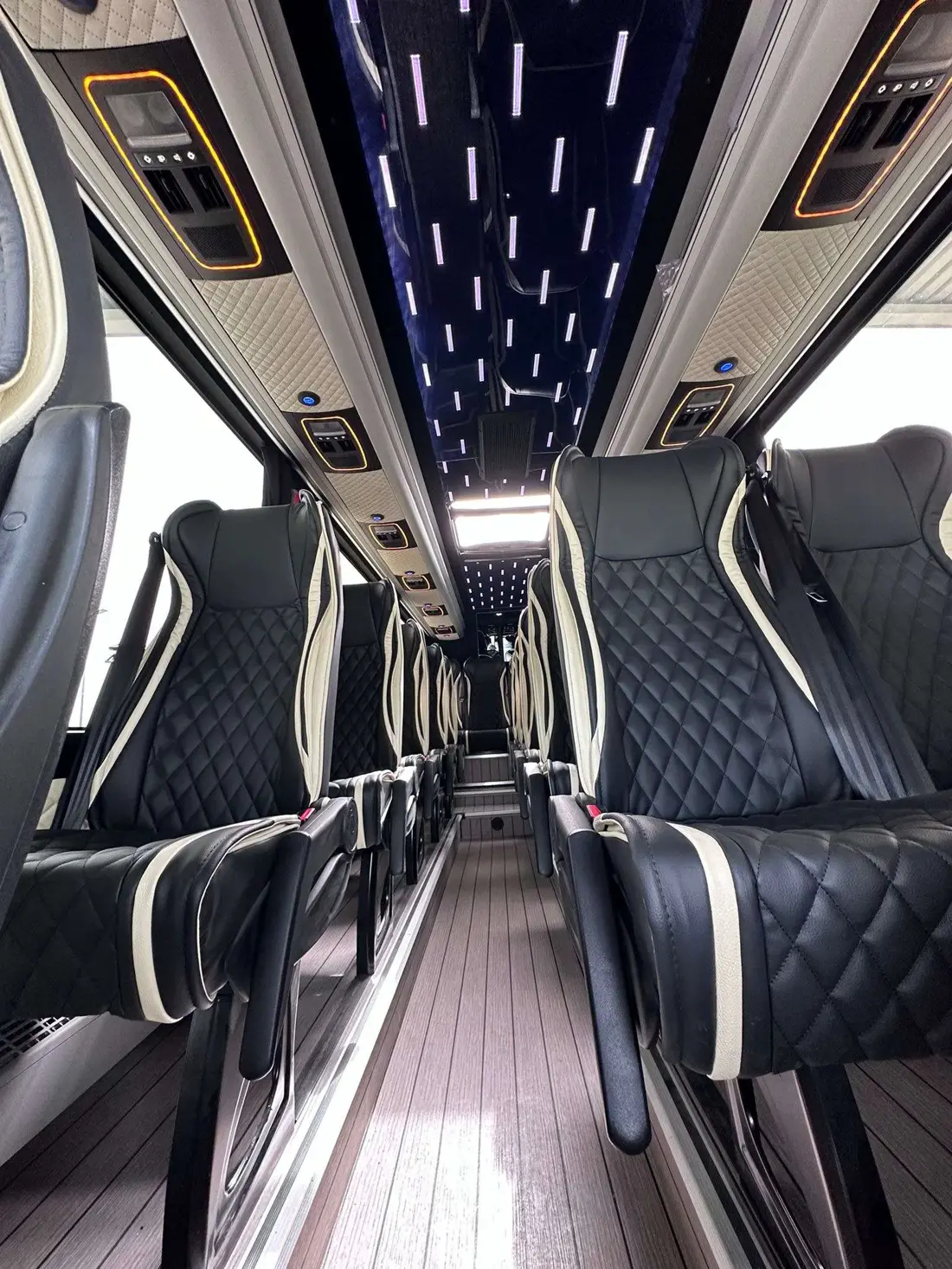 Interior of a Mercedes Sprinter minibus with quilted leather seats and a starlight ceiling